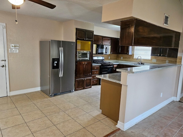 kitchen featuring black microwave, dark brown cabinetry, visible vents, stainless steel refrigerator with ice dispenser, and gas stove