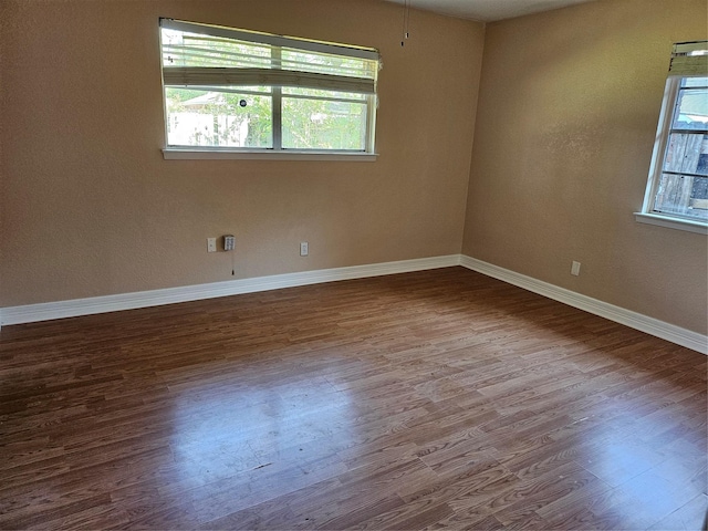 spare room with wood finished floors and baseboards