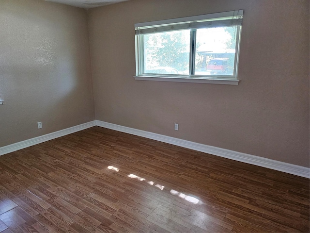 unfurnished room featuring baseboards and wood finished floors