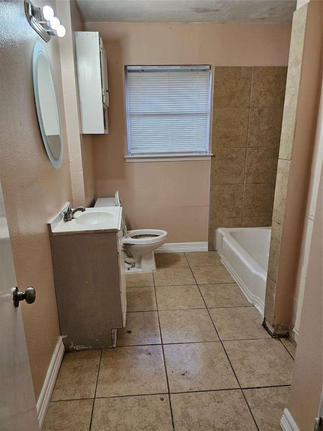 bathroom featuring baseboards, vanity, toilet, and tile patterned floors