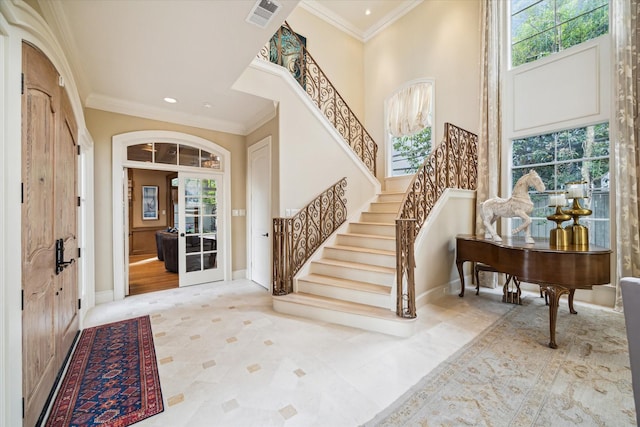 foyer entrance with stairs, baseboards, visible vents, and crown molding