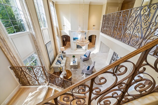 stairway featuring plenty of natural light and crown molding