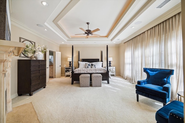 bedroom featuring light colored carpet, visible vents, baseboards, a tray ceiling, and crown molding