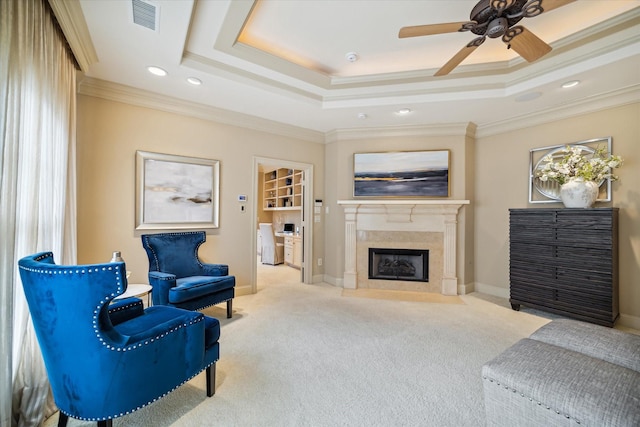 living area with ornamental molding, a raised ceiling, and visible vents