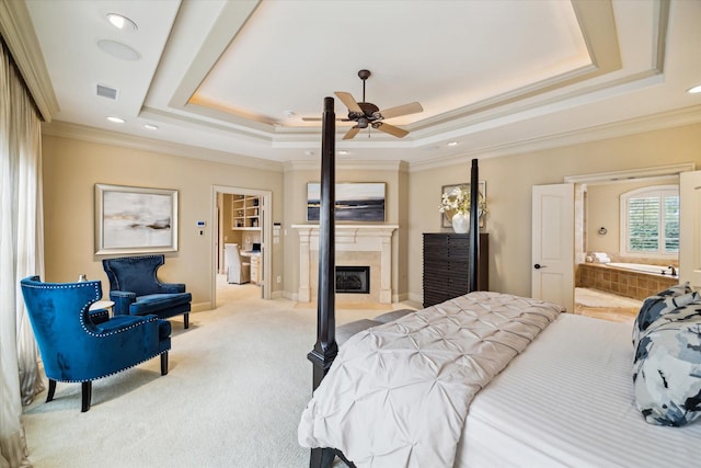 bedroom with light carpet, visible vents, a tray ceiling, and crown molding