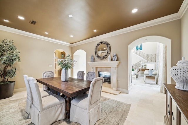 dining room featuring arched walkways, visible vents, a fireplace, and recessed lighting