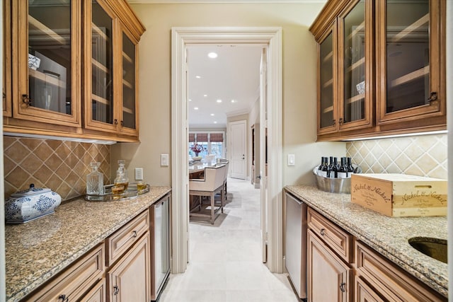 kitchen featuring tasteful backsplash, glass insert cabinets, brown cabinets, ornamental molding, and light stone countertops