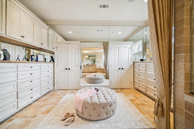 spacious closet with stone tile flooring and visible vents