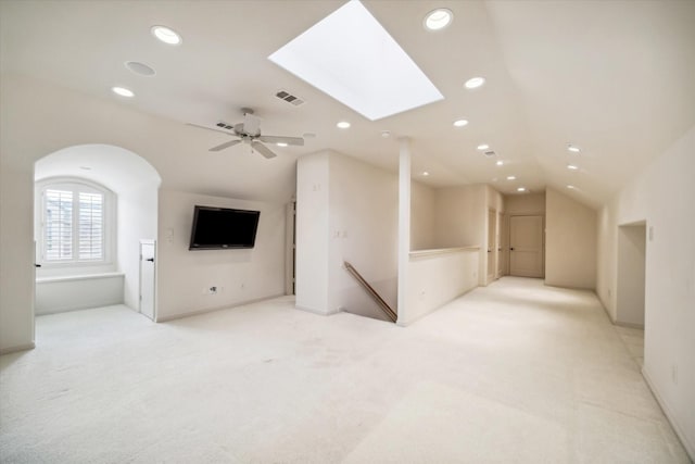 interior space with lofted ceiling with skylight, recessed lighting, light colored carpet, and visible vents