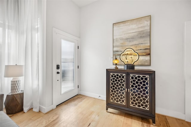 entryway featuring baseboards and light wood finished floors