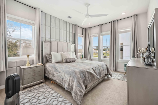 bedroom with light carpet, a ceiling fan, visible vents, and recessed lighting