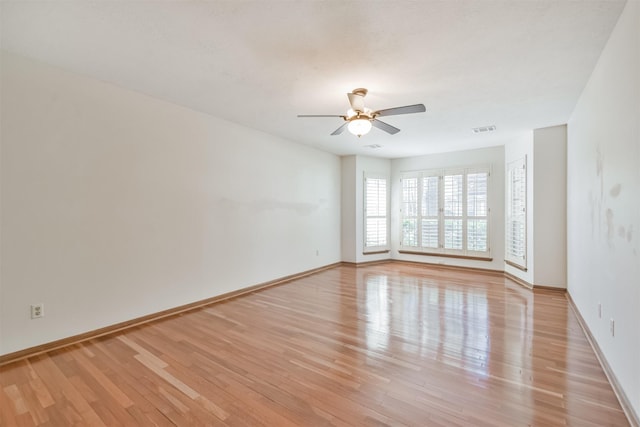 spare room featuring light wood-style floors, baseboards, and visible vents