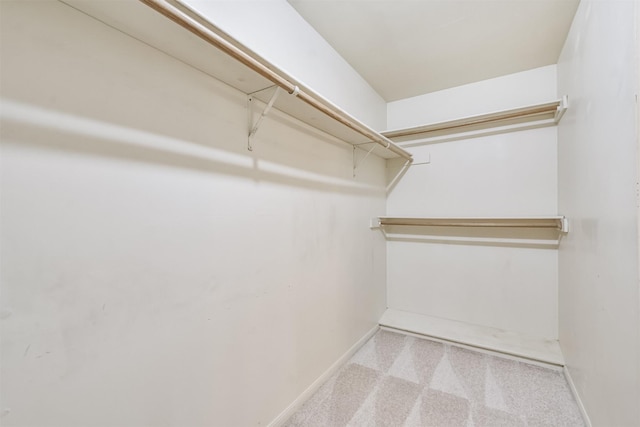 walk in closet featuring light colored carpet