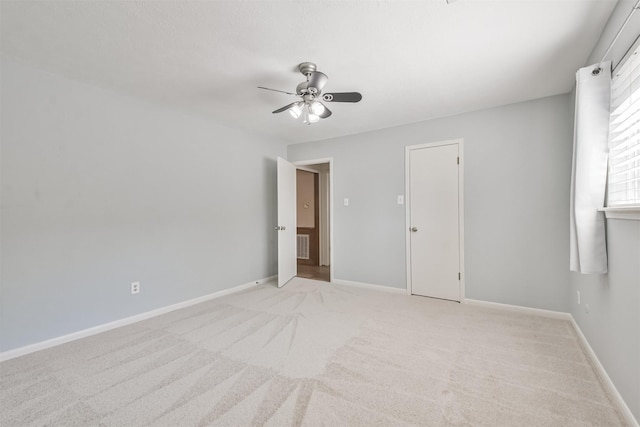 unfurnished bedroom with light carpet, ceiling fan, visible vents, and baseboards