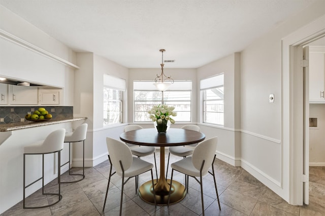 dining room with a healthy amount of sunlight, visible vents, and baseboards