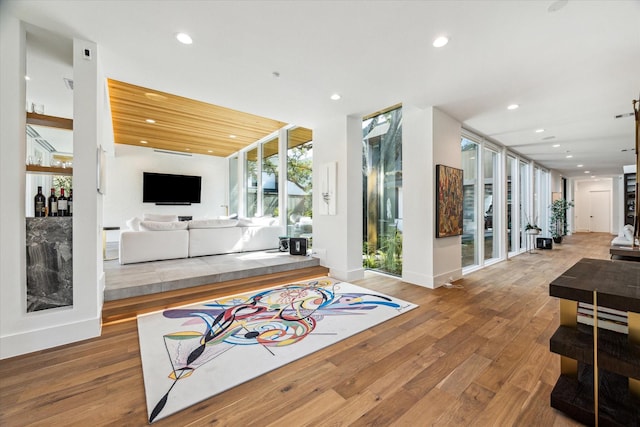 interior space featuring expansive windows, baseboards, wood finished floors, and recessed lighting