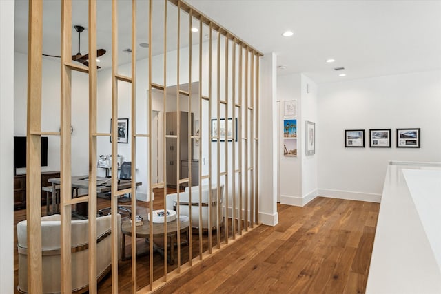 hallway featuring recessed lighting, baseboards, and wood finished floors