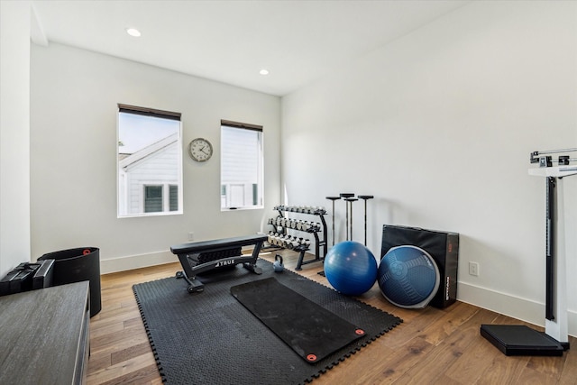 exercise area with recessed lighting, light wood-style flooring, and baseboards