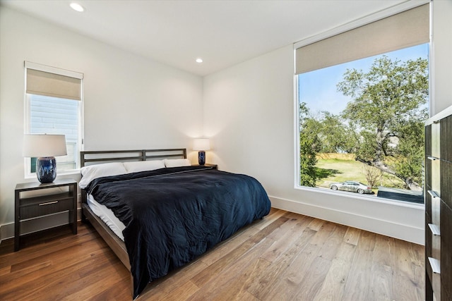 bedroom with recessed lighting, baseboards, and wood finished floors