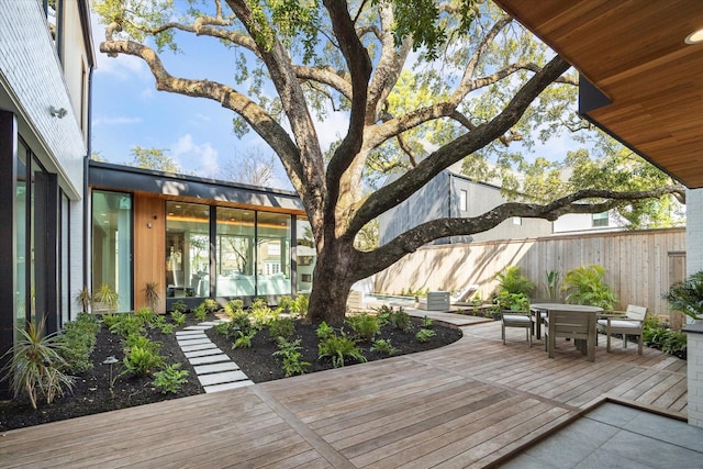 wooden terrace featuring outdoor dining space and fence