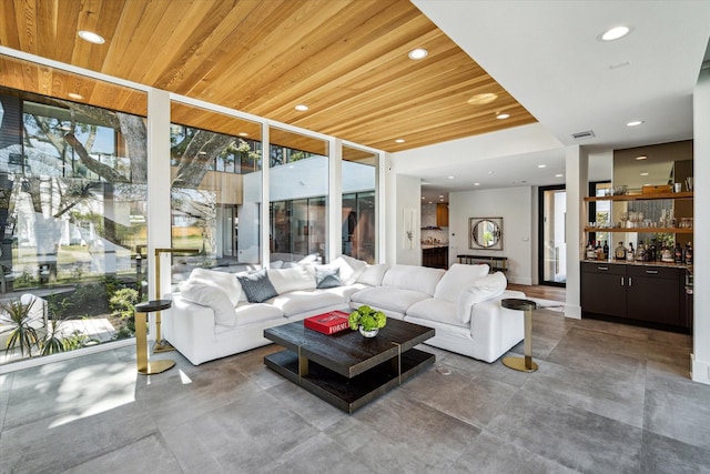 living area featuring wooden ceiling, recessed lighting, visible vents, floor to ceiling windows, and a bar