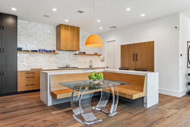 kitchen featuring dark wood-style floors, decorative light fixtures, open shelves, light countertops, and modern cabinets