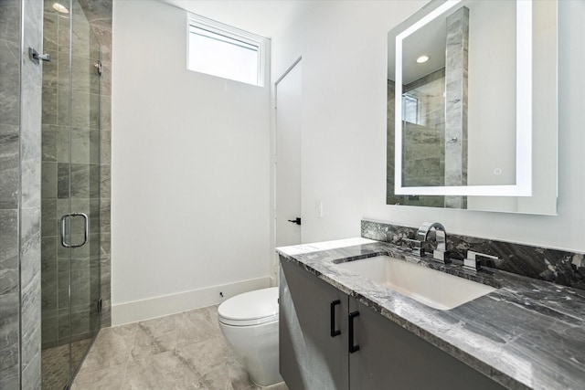 bathroom featuring toilet, a stall shower, baseboards, and vanity