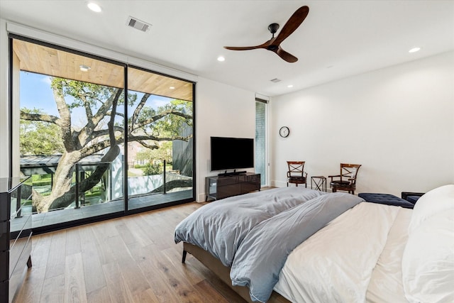 bedroom featuring recessed lighting, wood finished floors, visible vents, access to exterior, and a wall of windows