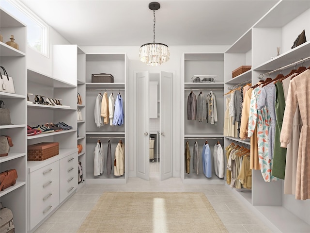 spacious closet featuring an inviting chandelier and light tile patterned flooring