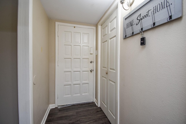 doorway to outside with baseboards and dark wood-type flooring