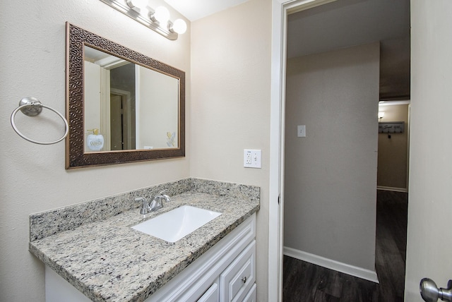 bathroom featuring vanity, baseboards, and wood finished floors