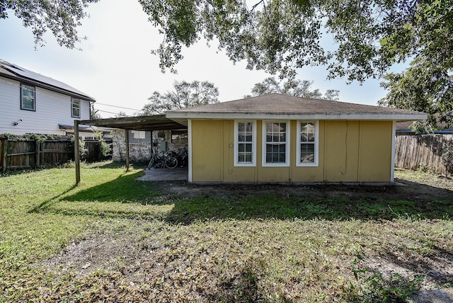 back of house with a fenced backyard and a lawn