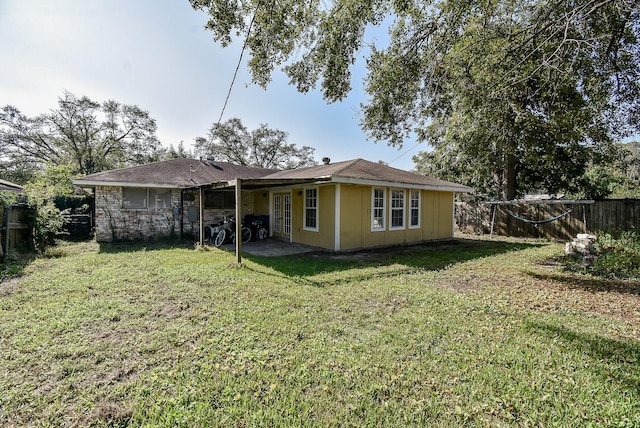 back of property featuring a patio area, fence, and a lawn