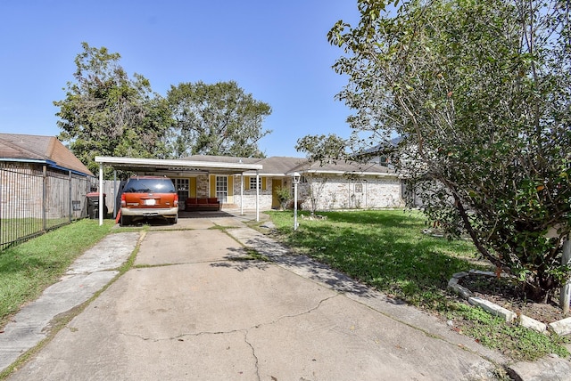 view of front facade featuring an attached carport, a front yard, fence, and driveway