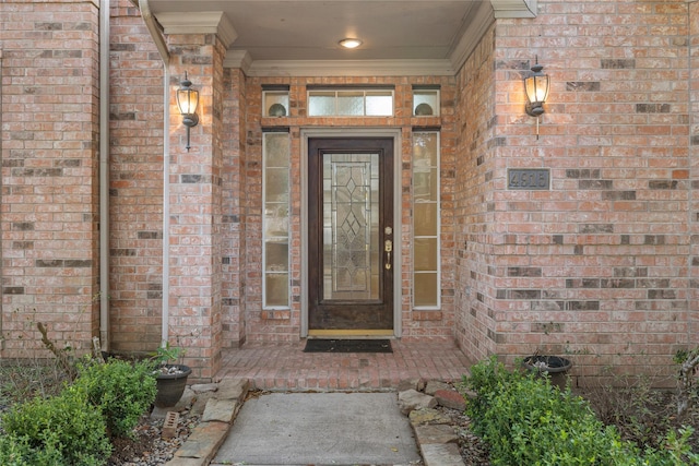 view of exterior entry with brick siding