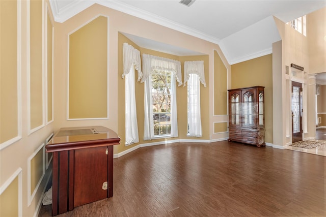 entrance foyer with dark wood finished floors, lofted ceiling, visible vents, ornamental molding, and baseboards