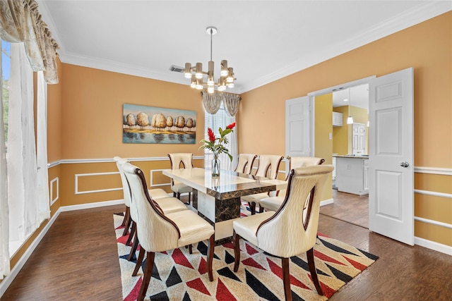 dining area featuring dark wood-style floors, baseboards, ornamental molding, and an inviting chandelier