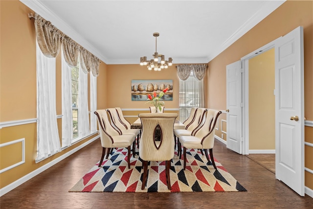 dining room with baseboards, ornamental molding, dark wood-style flooring, and an inviting chandelier