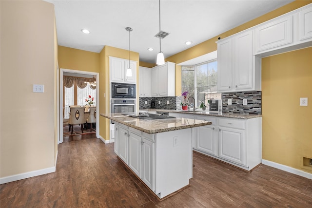 kitchen featuring light stone counters, a center island, and white cabinets