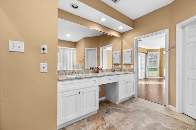 full bath with double vanity, a sink, and recessed lighting