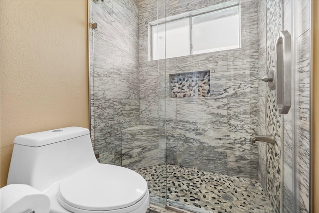 full bathroom featuring a textured wall, a shower stall, and toilet