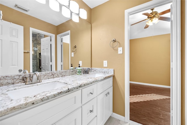 bathroom featuring visible vents, a sink, baseboards, and double vanity