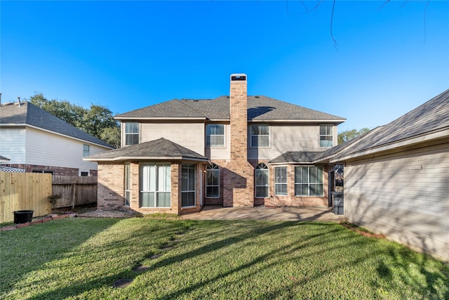 rear view of property with a lawn, a chimney, fence, a patio area, and brick siding