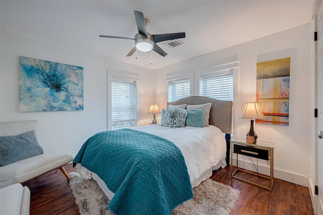 bedroom featuring ceiling fan, dark wood-type flooring, visible vents, and baseboards