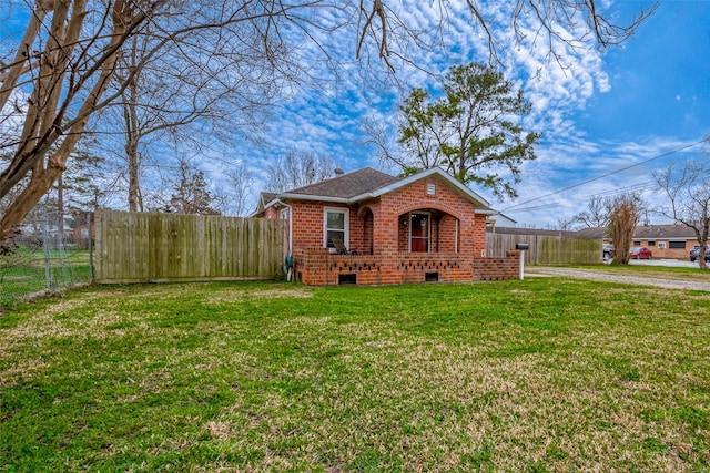 bungalow-style home featuring fence, a front lawn, and brick siding