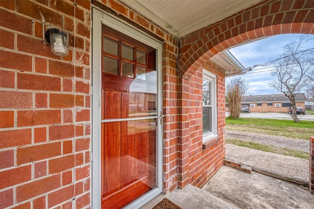 entrance to property featuring brick siding