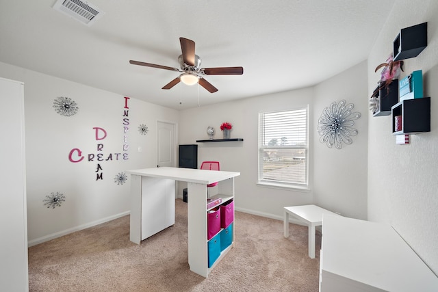 playroom featuring a ceiling fan, light colored carpet, visible vents, and baseboards