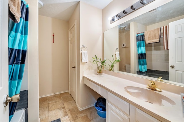 bathroom featuring toilet, vanity, baseboards, a shower with curtain, and stone finish flooring