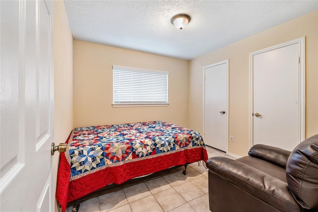 bedroom featuring light tile patterned flooring and a textured ceiling