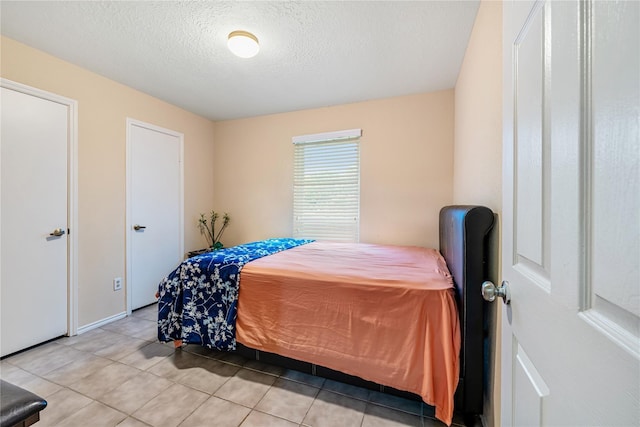 bedroom with light tile patterned floors and a textured ceiling